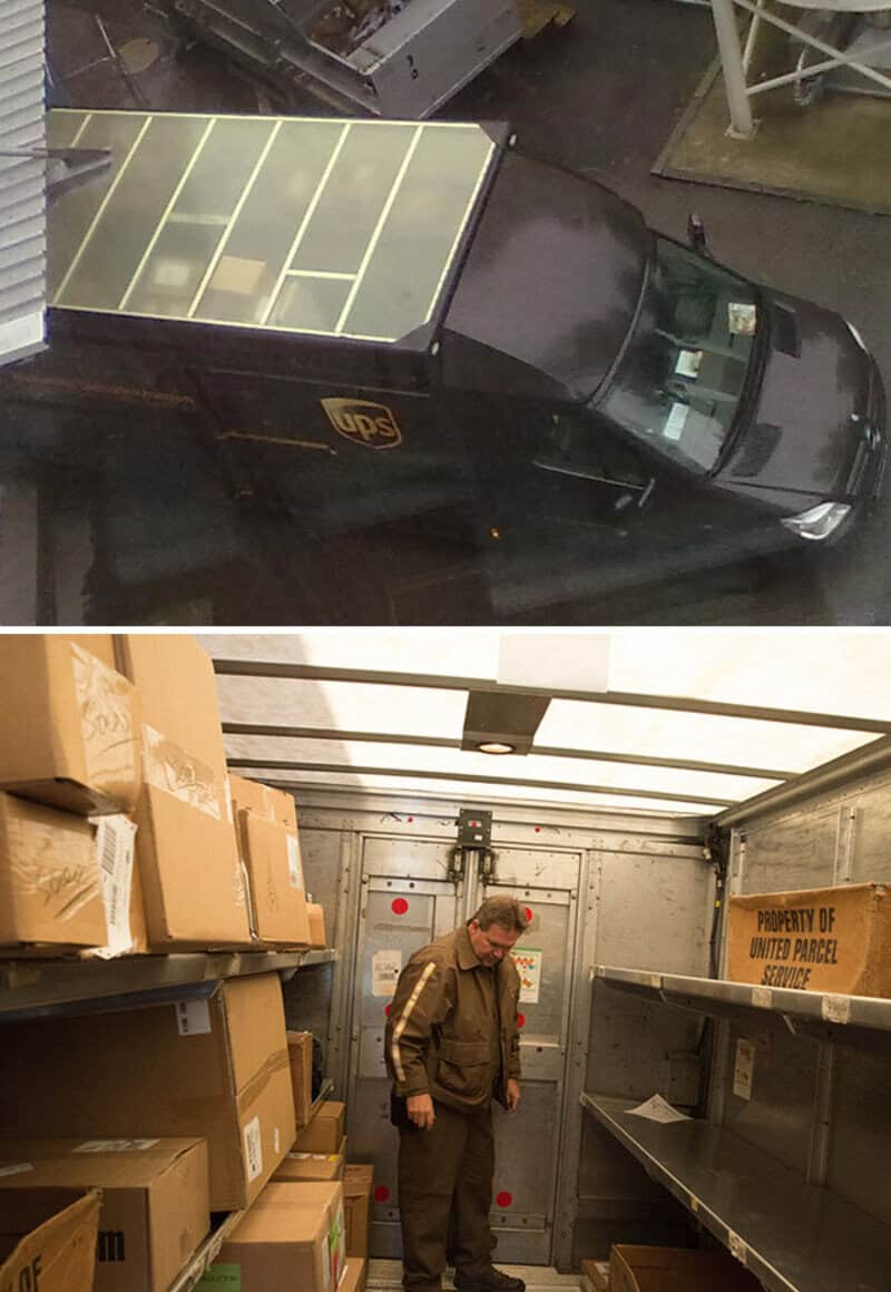 UPS delivery truck parked inside a warehouse with boxes and a man inspecting the area.