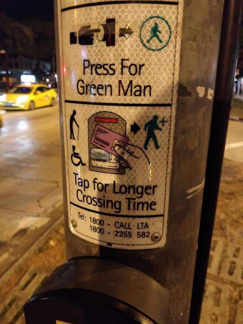 Sign with instructions to press for Green Man and tap for longer crossing time.