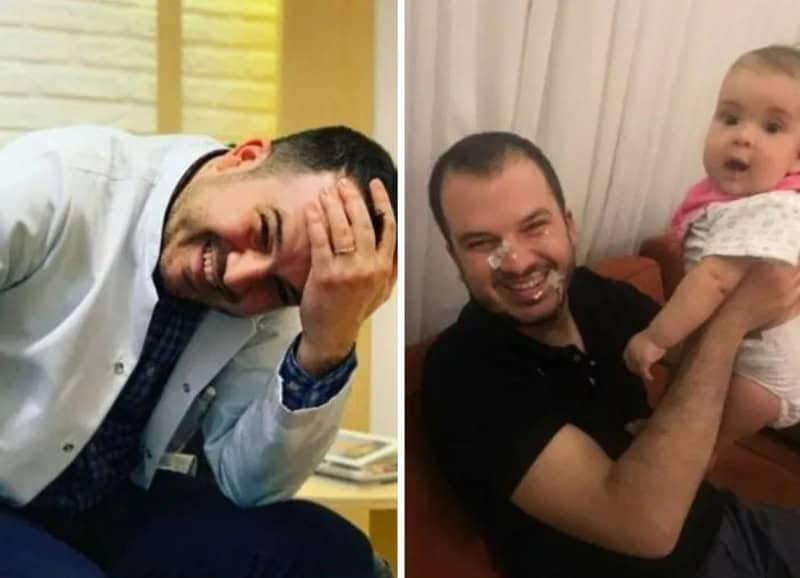Two men laughing, one with hand on forehead, the other holding a baby girl.