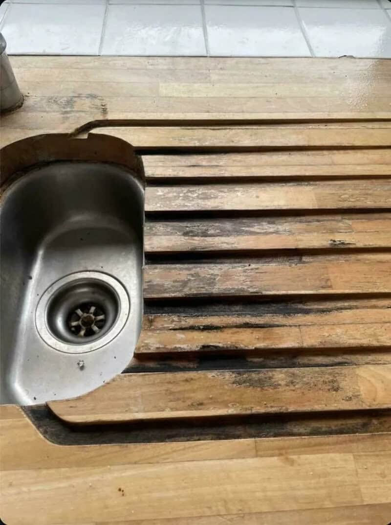 Wooden planks and a kitchen sink on a wooden surface.