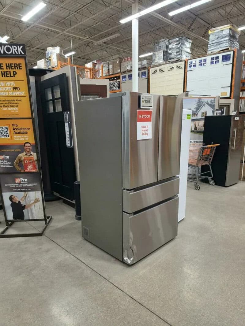 Stainless steel refrigerator on display at Home Depot store.