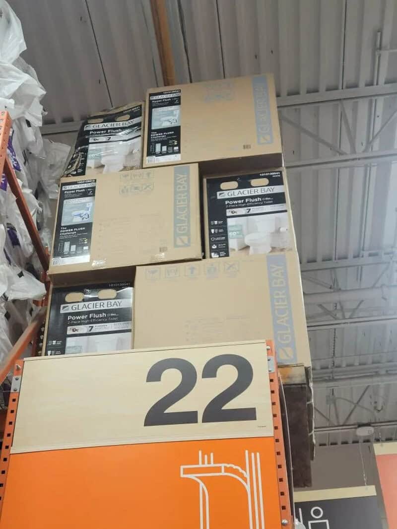 Stack of Glacier Bay power flush boxes on warehouse shelf with large orange and black number 22 sign.