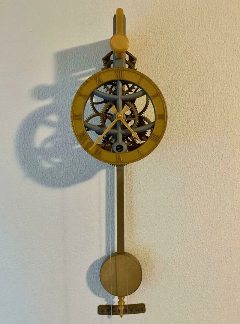 Mechanical clock with visible gears and pendulum, mounted on a wall.