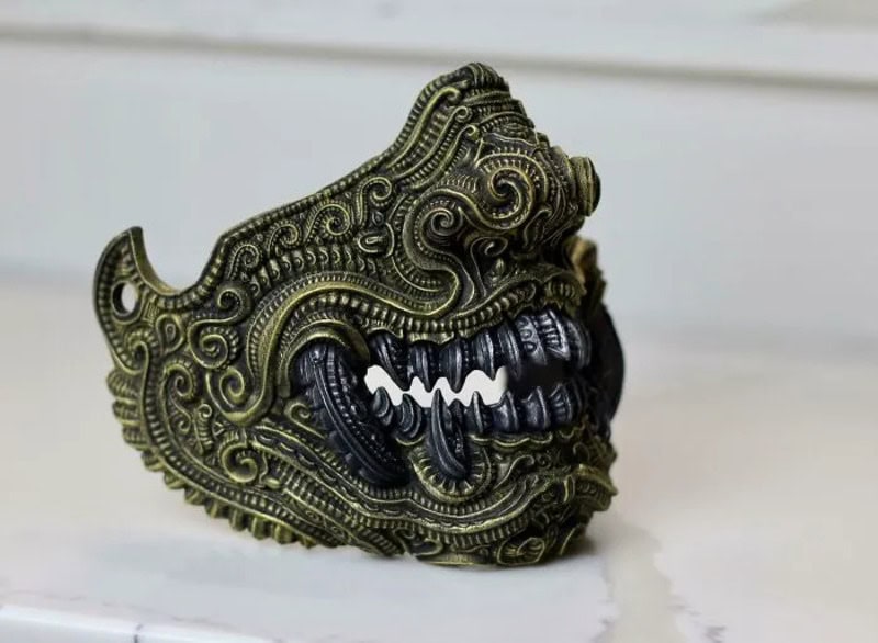 Detailed metallic dragon head sculpture with intricate patterns and black teeth.