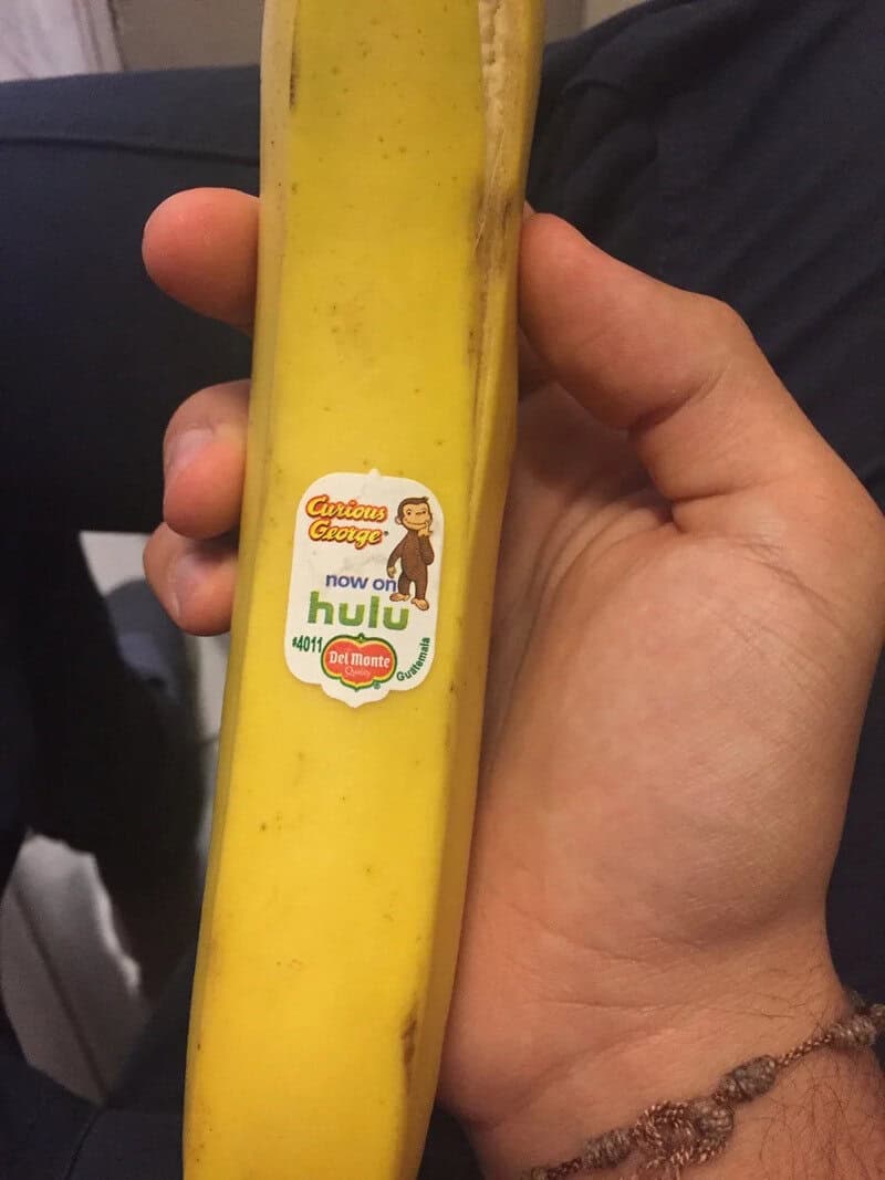 Banana with a sticker that says 'Caution: Energy now on Hulu' and 'Del Monte'.