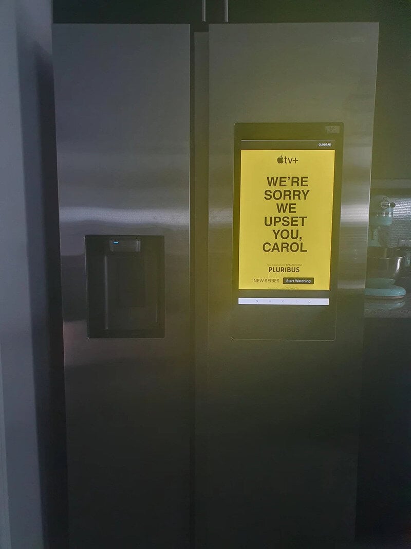 Refrigerator with a yellow screen saying 'We're sorry we upset you, Carol'.