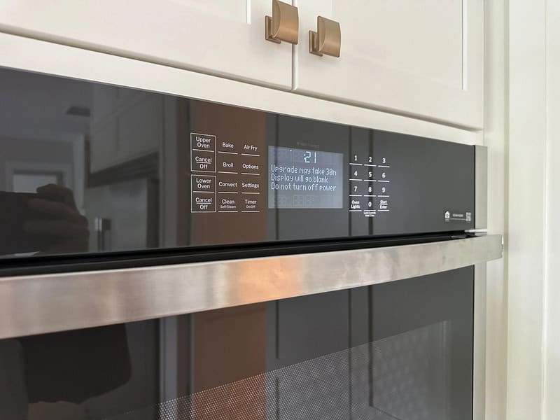 Microwave oven with digital display and control panel in a kitchen.