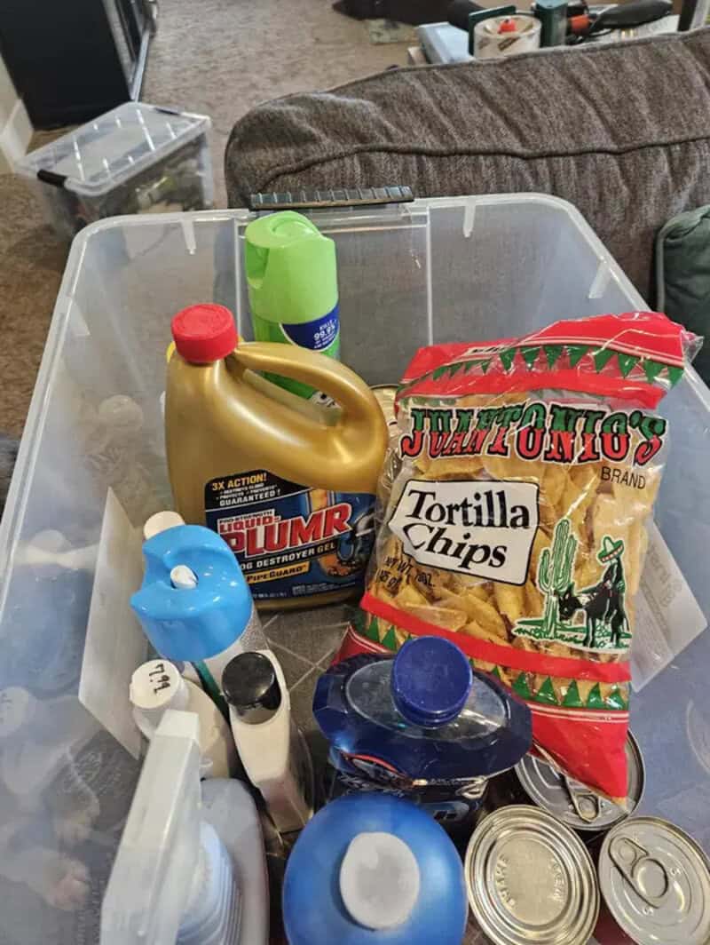 Cleaning supplies and tortilla chips in a plastic storage bin.