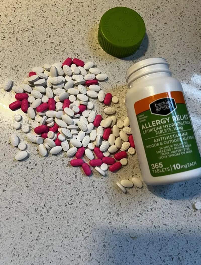 Pills spilled from a bottle labeled allergy relief on a countertop.