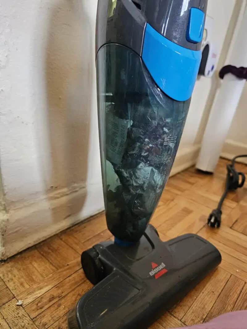 Vacuum cleaner with blue and black design on wooden floor.