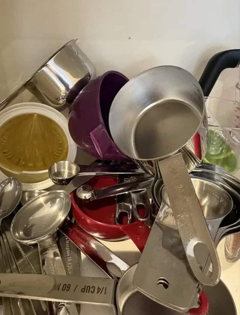 Piles of dirty kitchen utensils and pots stacked haphazardly.