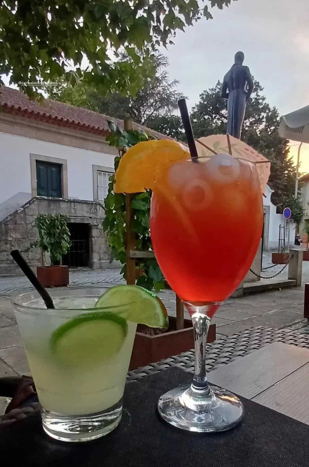 Colorful cocktails with lime and orange garnishes on an outdoor table.