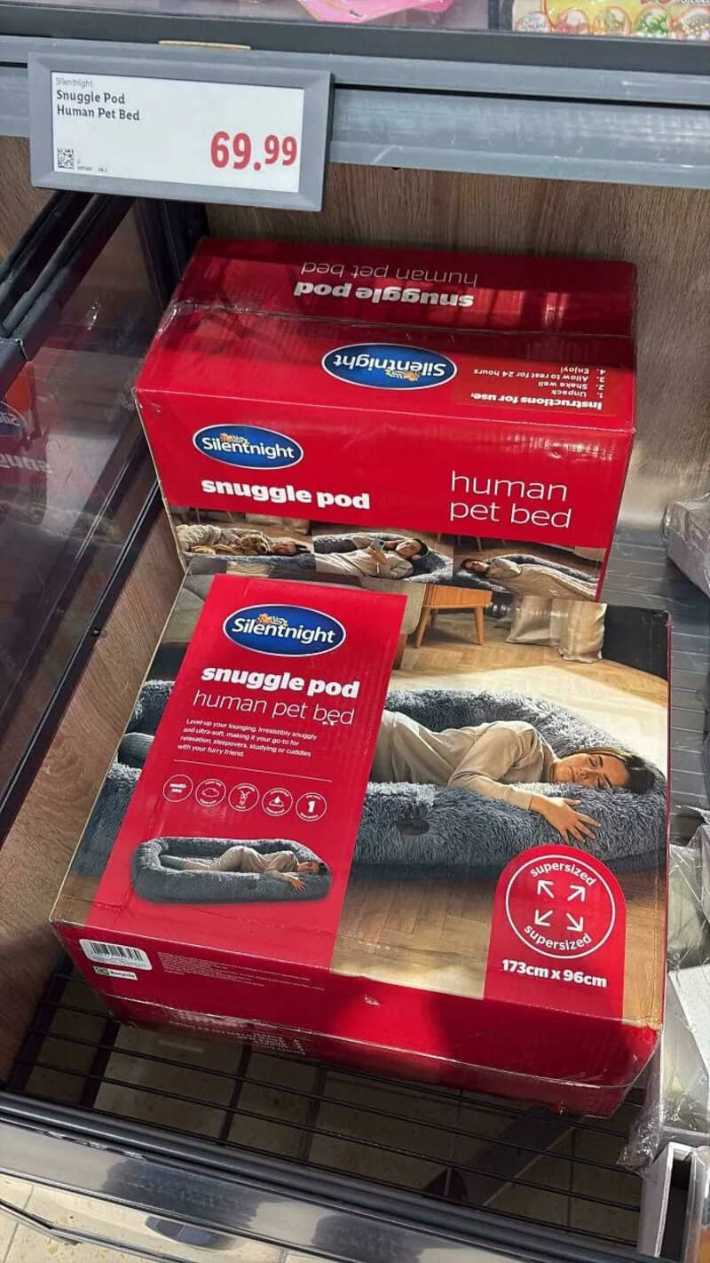Red box of Snuggle Pod human pet bed on store shelf with price tag 69.99.