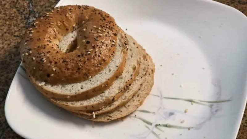 Stacked bagels on a white plate with a floral design.
