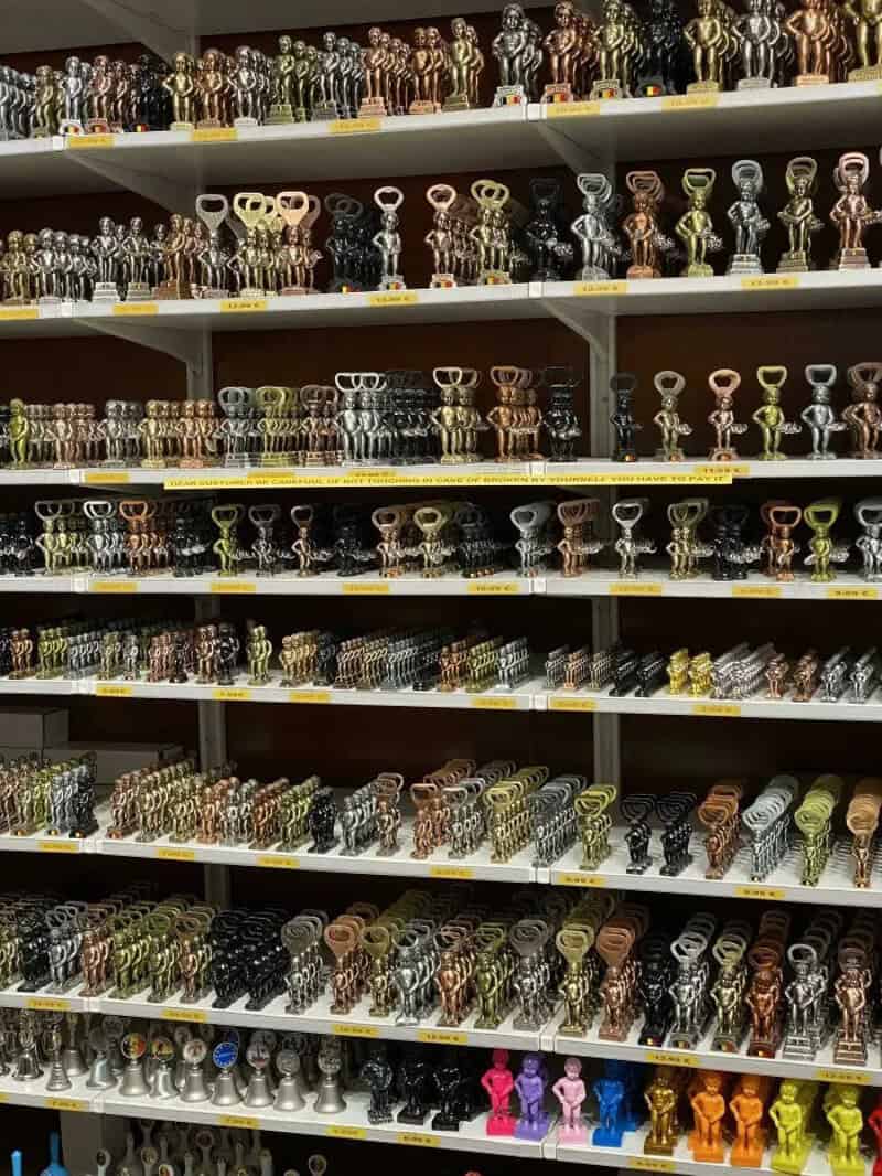 Shelf filled with various colorful and metallic door handles and knobs.