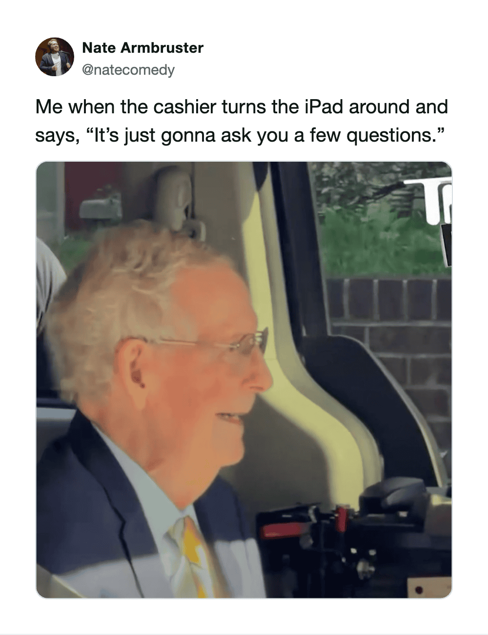 Older man smiling, sitting in a vehicle, with a caption about a cashier asking questions.