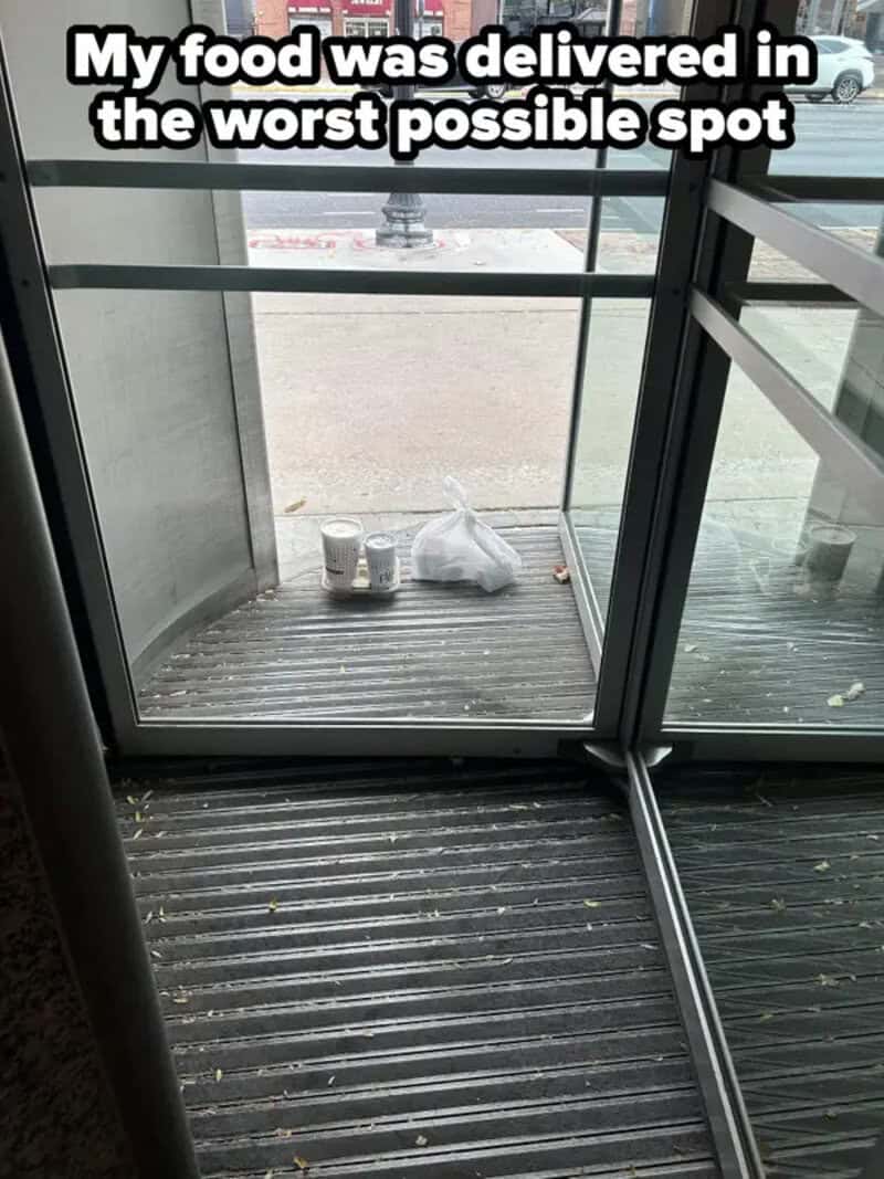 Food delivery on a dirty balcony floor with trash and cups, outside view visible.