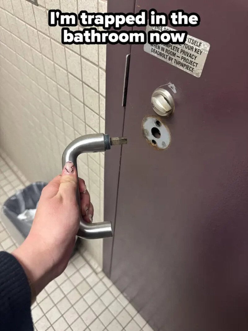 Person's hand holding a door handle in a bathroom with text overlay.
