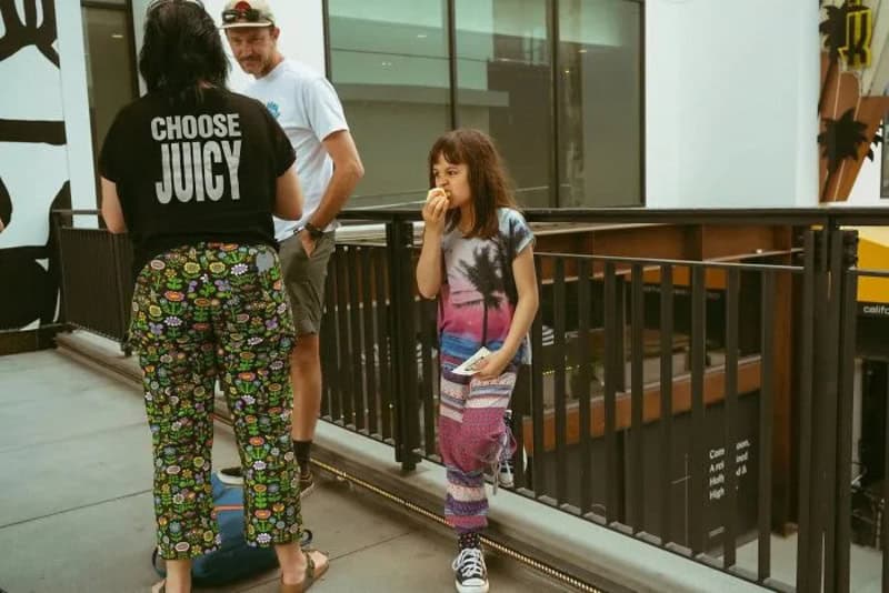 Girl eating ice cream with two adults in a shopping mall.