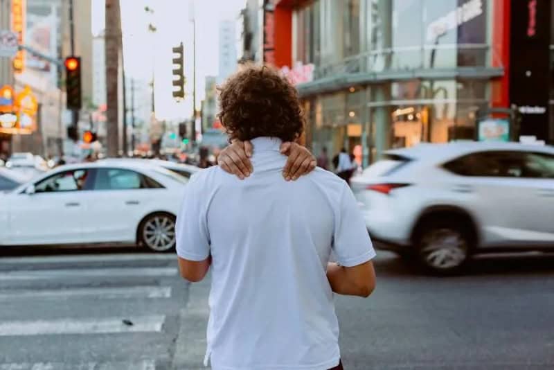 Person with curly hair crossing the street in Los Angeles.