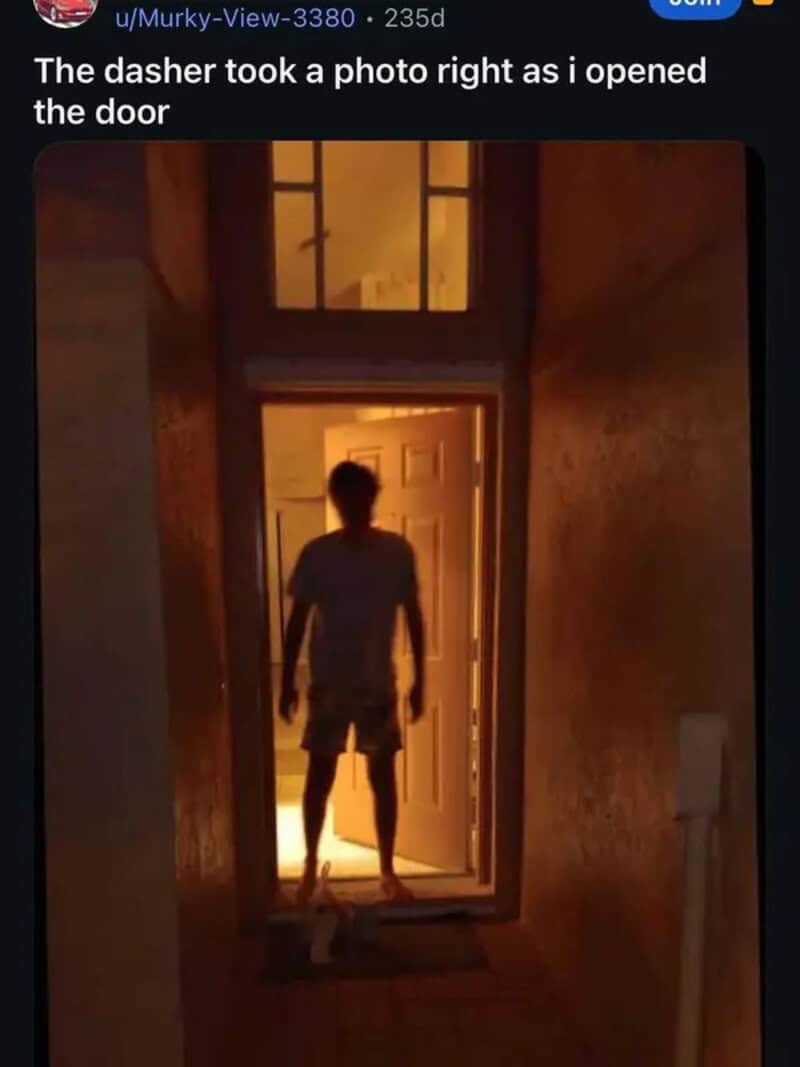 Silhouette of a person standing in a doorway with warm light behind them.
