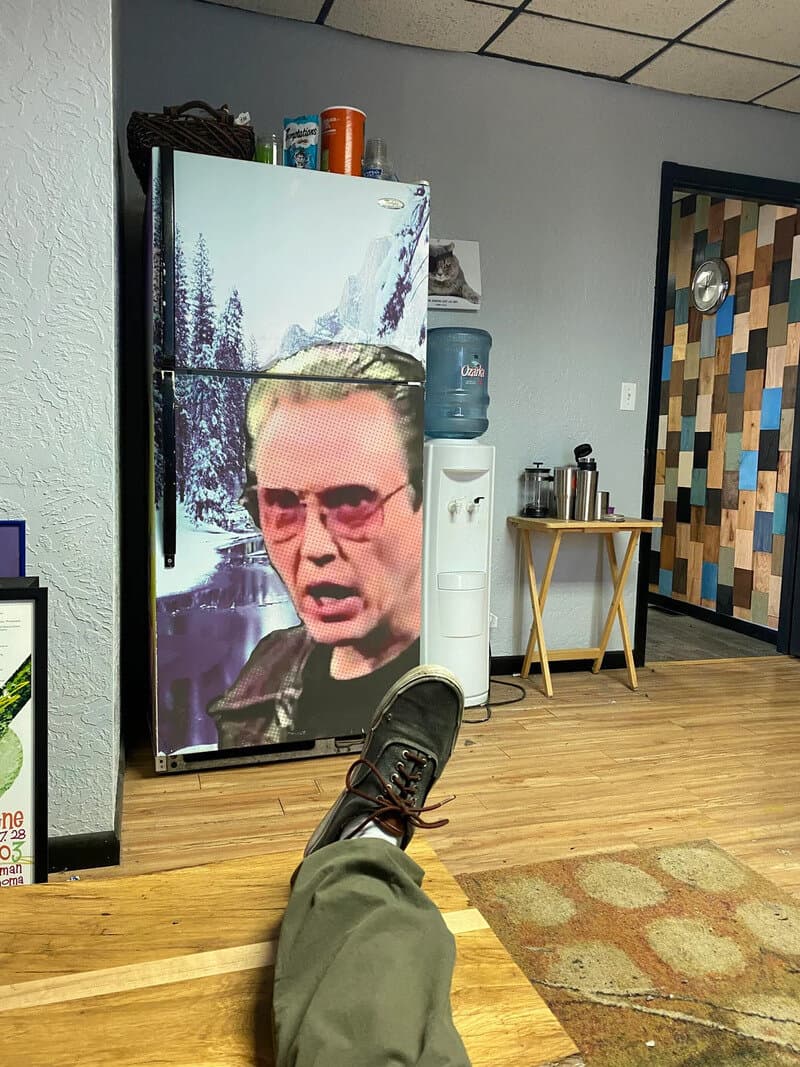 Refrigerator with a large image of a man's face and a mountain landscape.