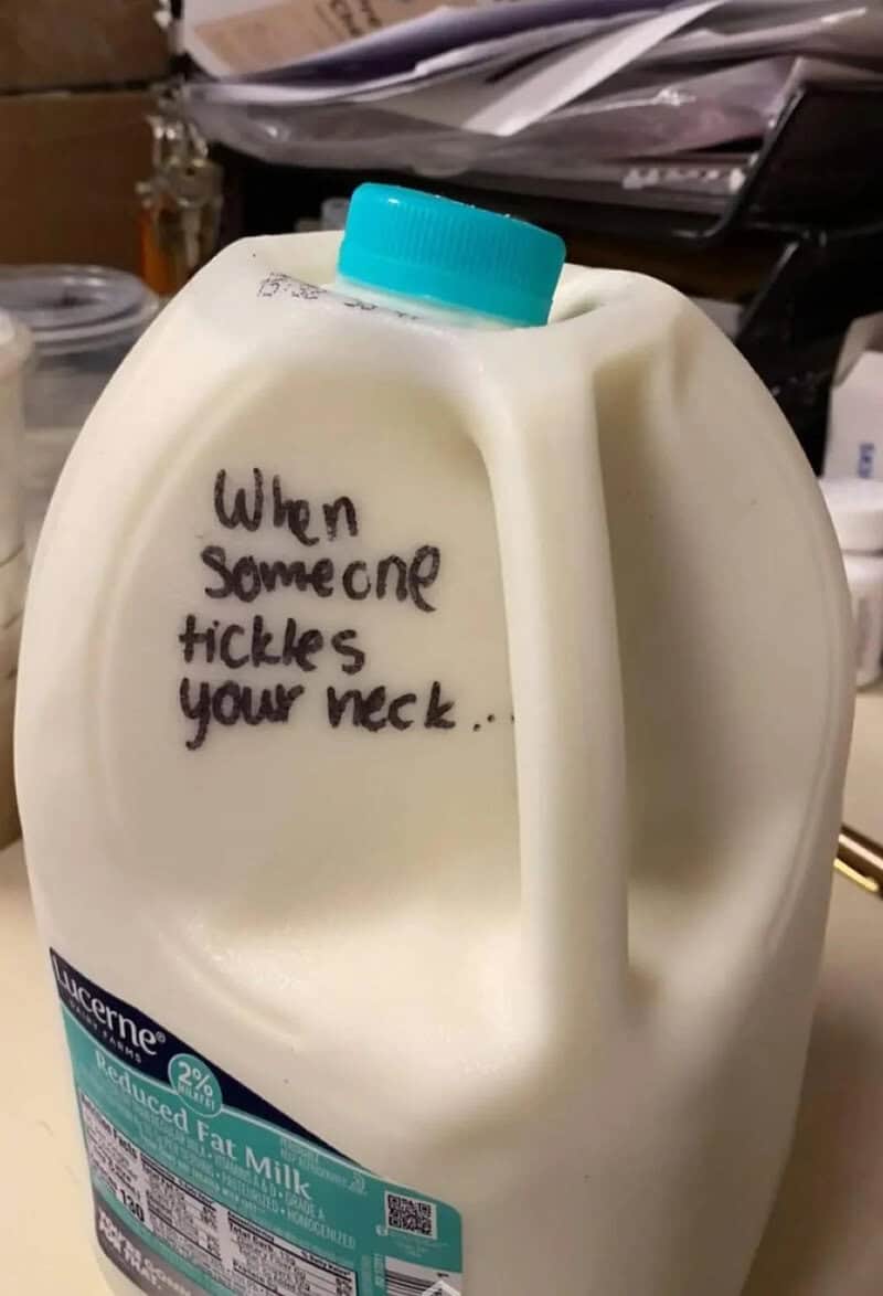 Milk jug with handwritten note: 'When someone tickles your neck...'.