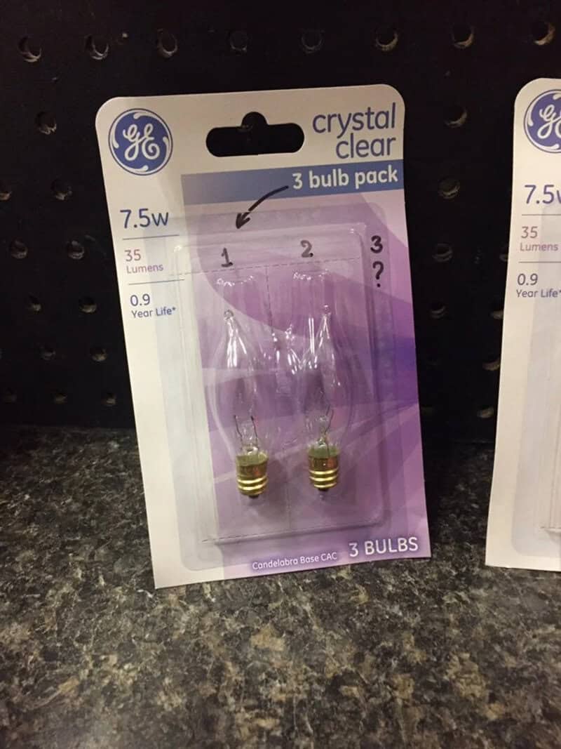 Pack of three GE crystal clear 7.5W light bulbs on store shelf.