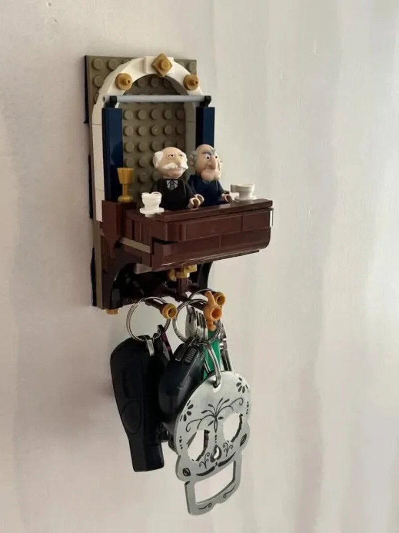 Lego wall decor with two figurines at a table, keys, and a skull-shaped bottle opener.