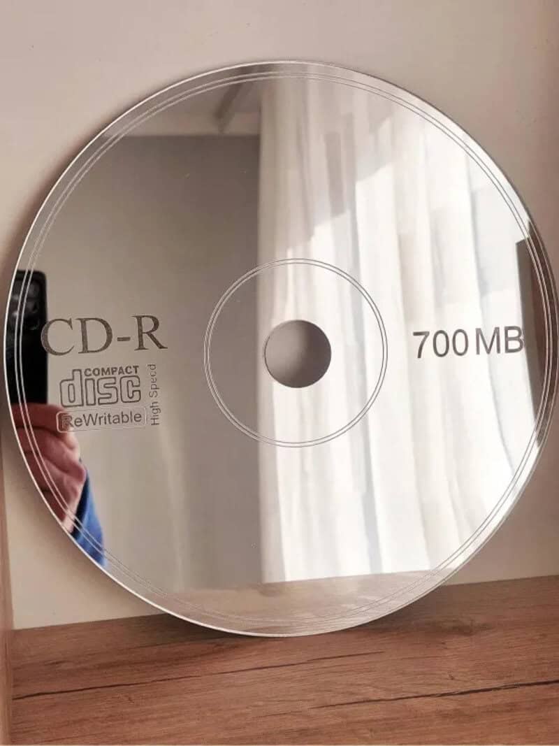 Compact disc with 700 MB capacity and CD-R label, reflected in a mirror.