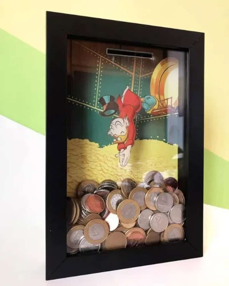 Piggy bank with coins and a cartoon pig inside a glass case.