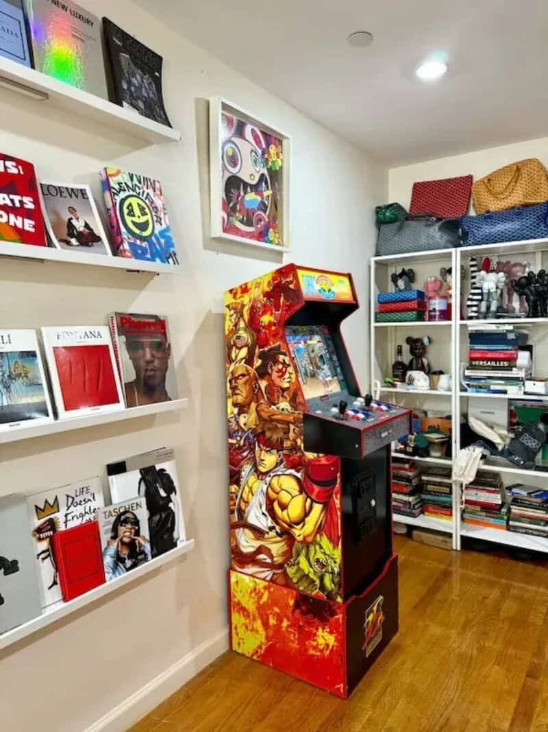 Colorful arcade game machine in a room with bookshelves and artwork.
