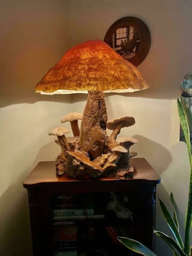 Lampshade shaped like a mushroom on a wooden table with a plant nearby.