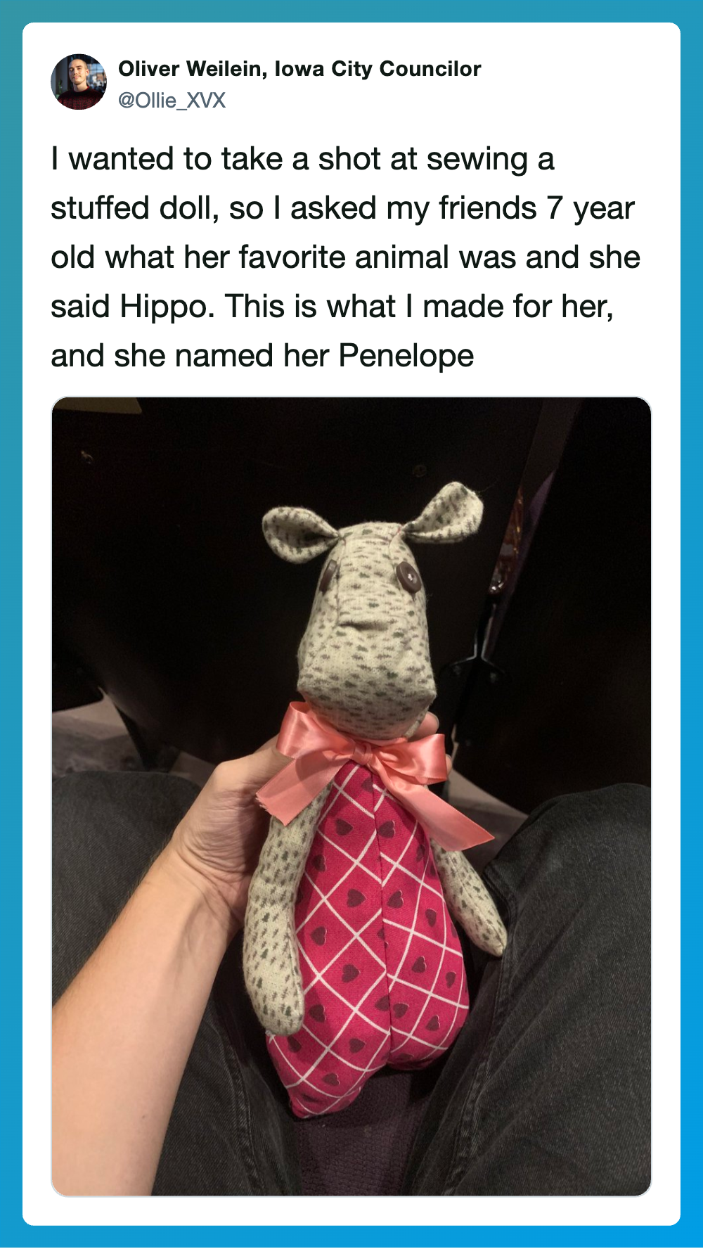 A stuffed animal doll resembling a hippo with a pink dress and bow.