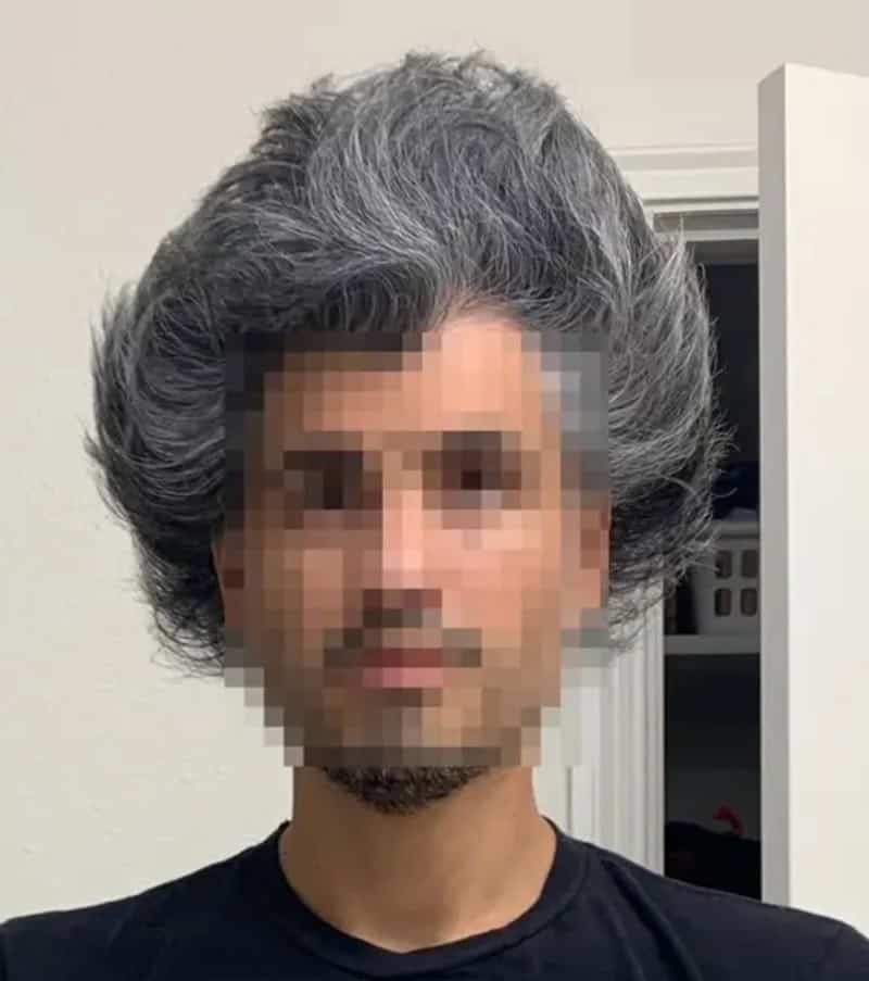Pixelated image of a man with gray hair and a beard, wearing a black shirt.