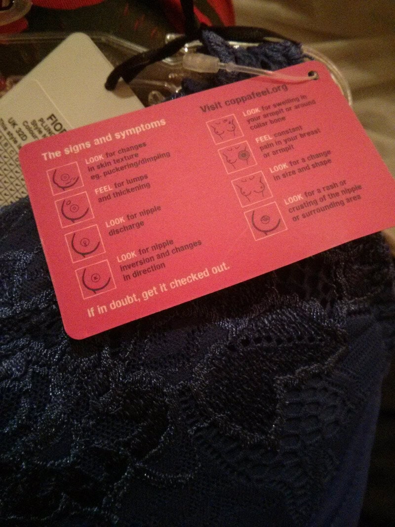 Pink tag with symptoms and signs for carpal tunnel syndrome on dark lace fabric.