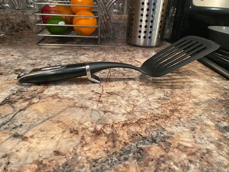 Slotted spatula with a hidden bottle opener in the handle.