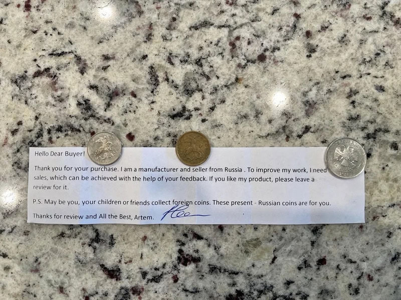 Russian coins and a handwritten note on a granite surface.