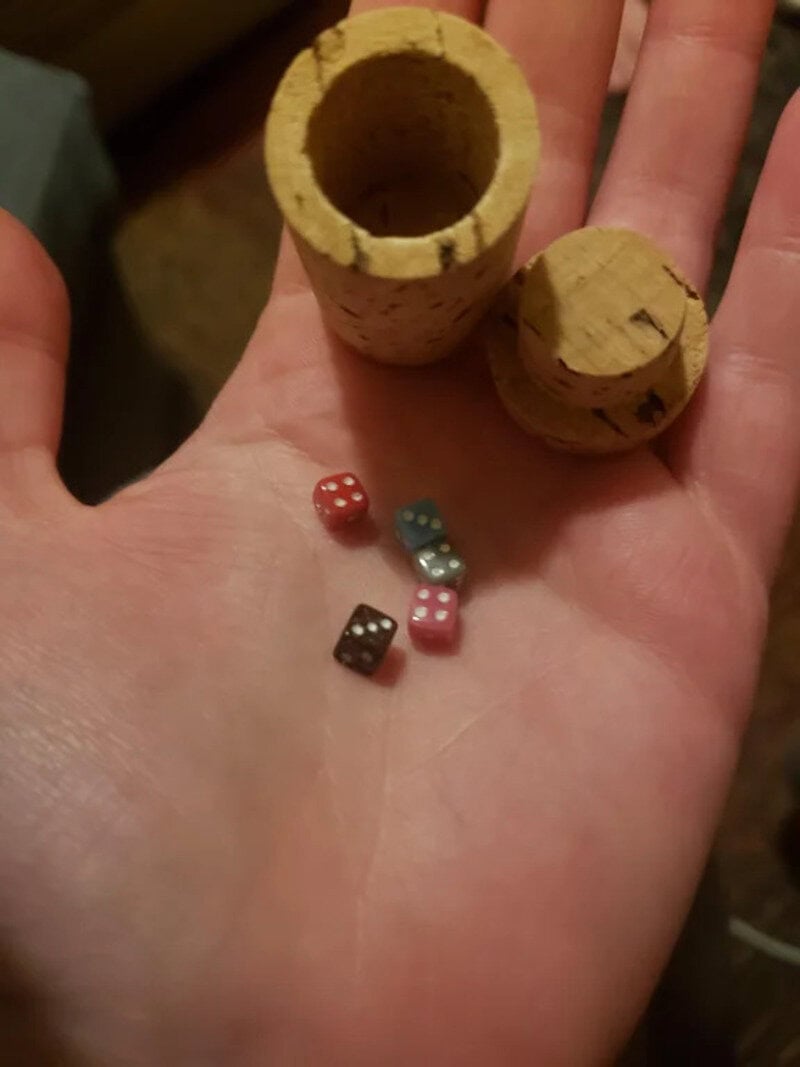 Cork container with dice inside and outside, part of a game or puzzle.