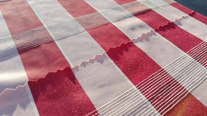 Close-up of a red and white checkered tablecloth with textured patterns.