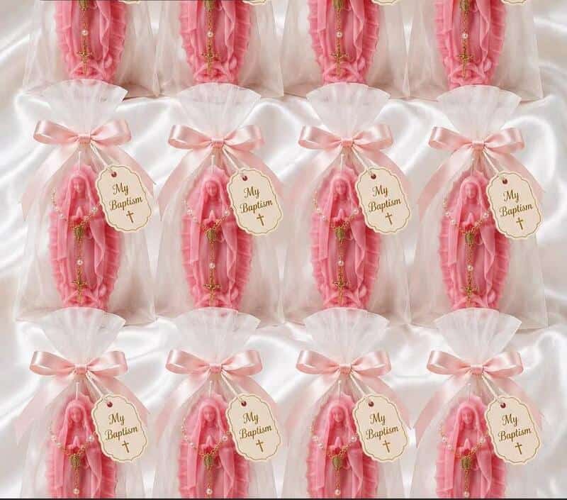 Multiple pink baptism candles wrapped in white and pink ribbons with 'My Baptism' tags.