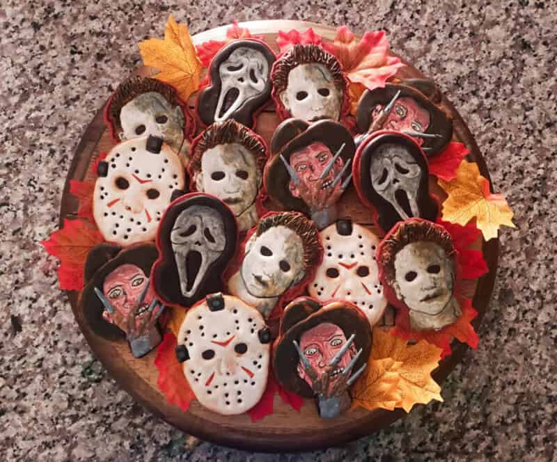 Assorted Halloween sugar cookies decorated as Ghostface, Jason, Michael Myers, and horror masks on a.