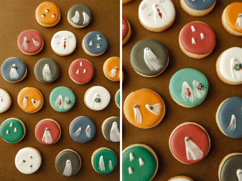 Colorful round cookies with small white ghost-like or bird-like decorations on brown surface; pastel.