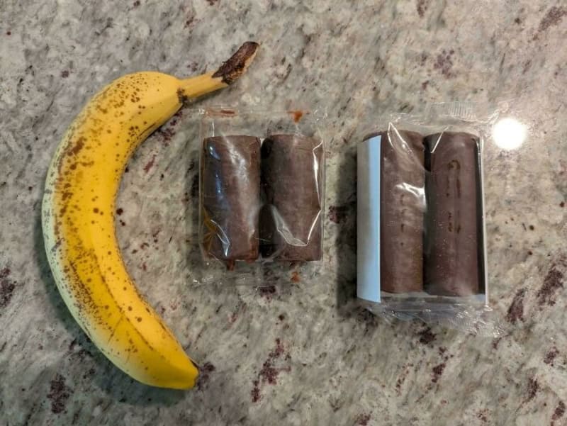 Banana and packaged chocolate bars on a speckled countertop.
