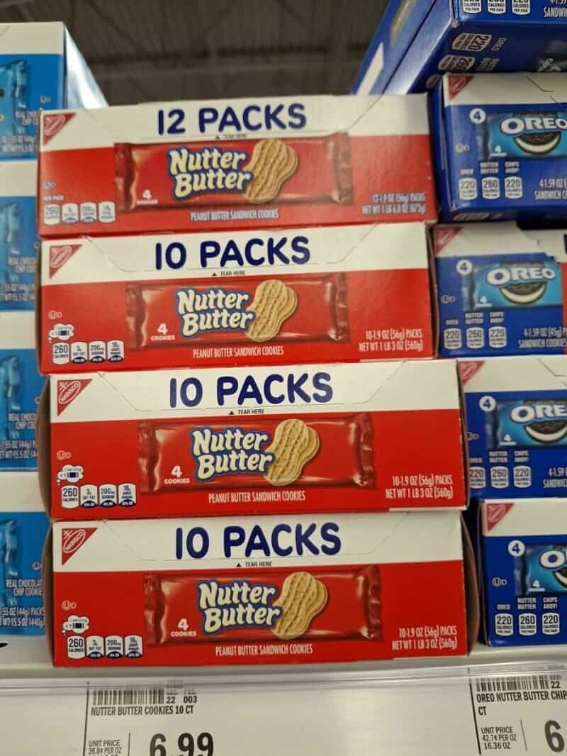 Stacks of Nutter Butter cookies in red boxes with '10 PACKS' and '12 PACKS' labels on a store shelf.