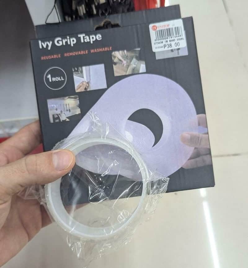 Ivy Grip Tape packaging with purple roll and hand holding tape, 1 roll, reusable and removable.