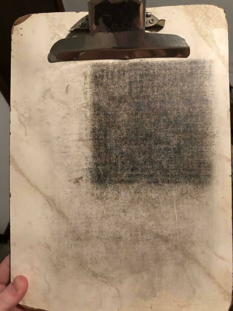 Worn clipboard with a dirty, smudged paper surface.