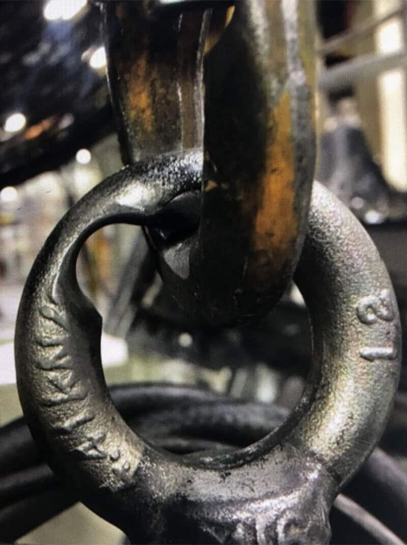 Close-up of a rusty metal ring attached to a chain link.