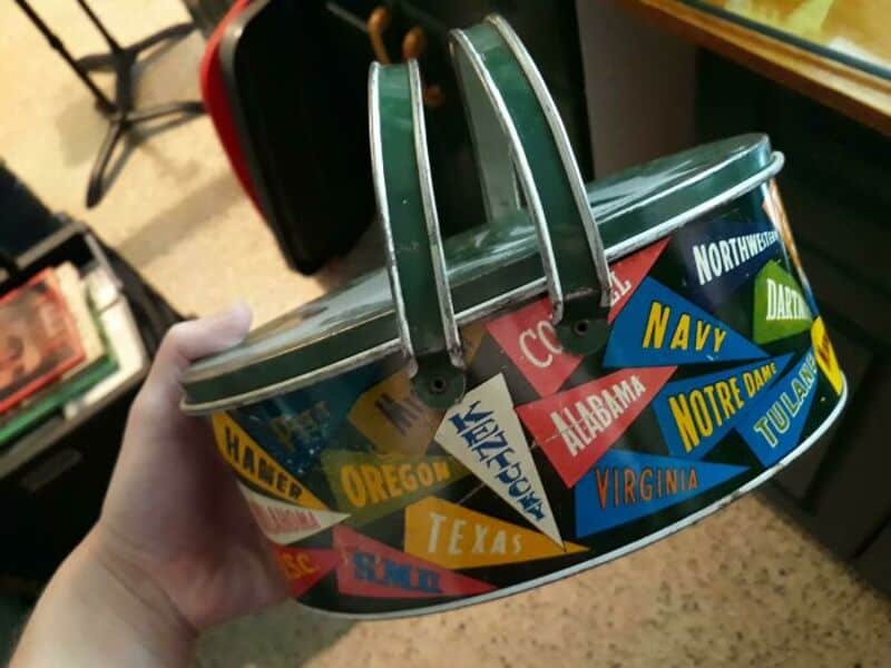 Colorful vintage metal lunchbox with state and military branch stickers.