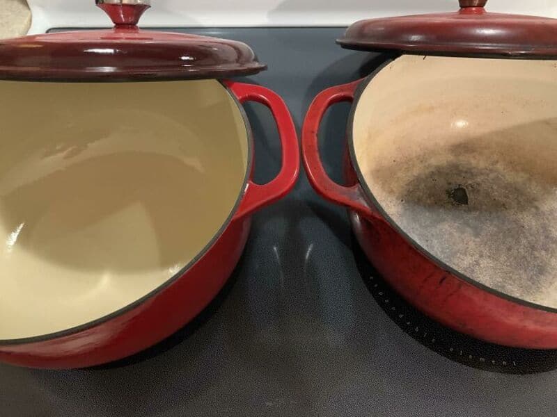 Two red cast iron pots with lids, one clean and one burnt and stained, on a black stovetop.